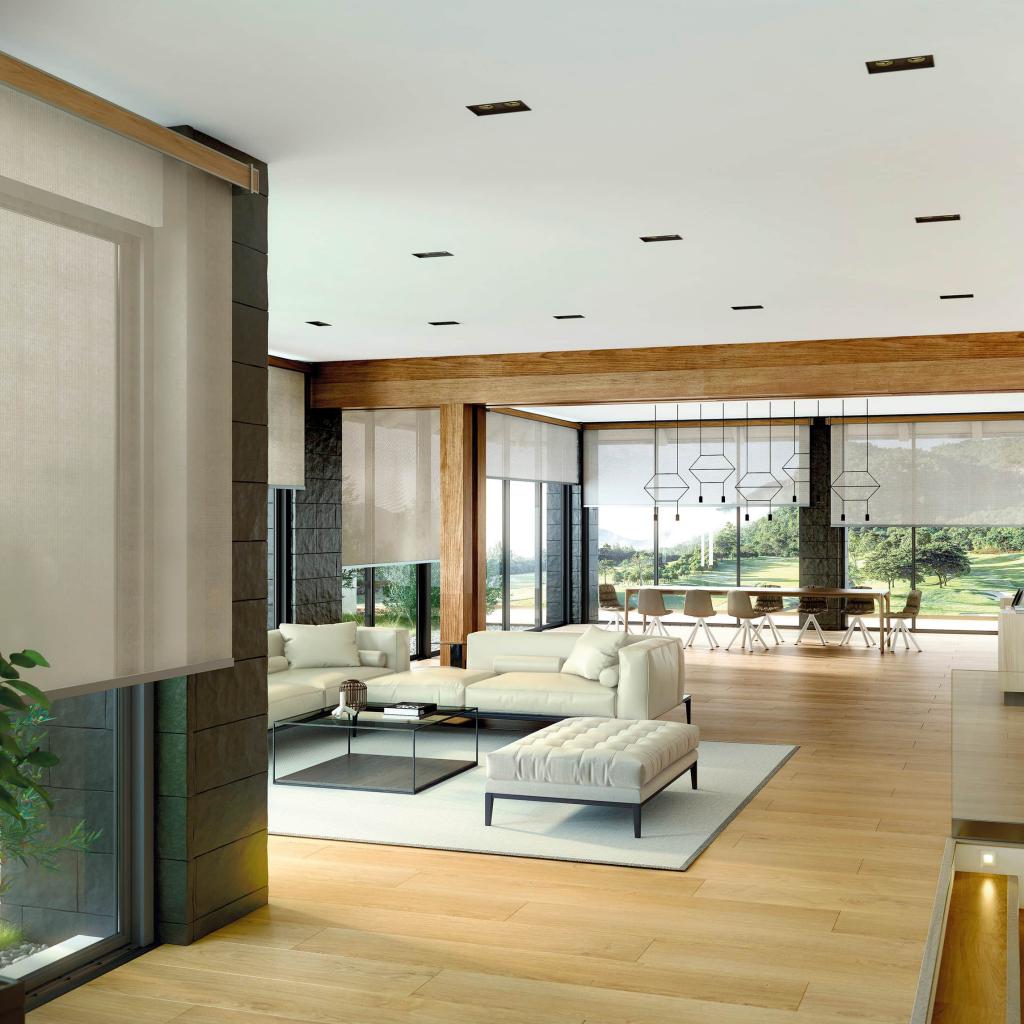 Salón amplio con estores traslúcidos Bandalux filtrando suavemente la luz y garantizando privacidad.