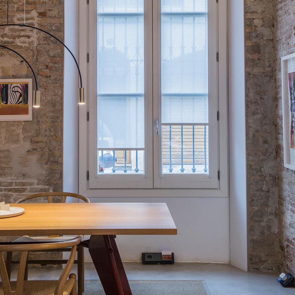 Ventana con estores sin taladrar Bandalux instalados sobre el marco, sin necesidad de perforar, filtrando luz ambiental.